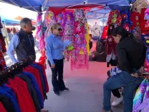 tianguis en Chihuahua con puestos de ropa, comida y ambiente lleno de gente en fin de semana