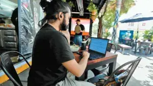 personas trabajando desde casa, haciendo home office mientras el partido esta en el fondo