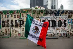 Familiares y colectivos de búsqueda sostienen fotografías de personas desaparecidas en México